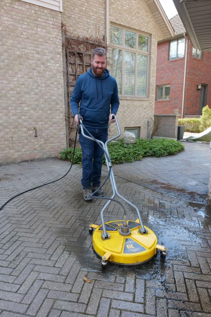 Joe Watling power washing an interlock driveway in Windsor-Essex County